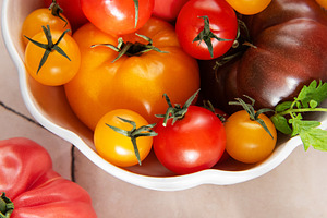 Fresh organic heirloom tomatoes in white bowl, a Food & Drink Photo by Olena Rudo