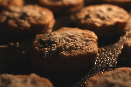 Cookies with almond flakes sprinkled with powdered sugar are baked in the oven, a Food & Drink Photo by Textures & Backgrounds