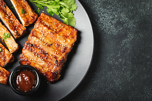 Hot grilled spare ribs from a summer BBQ served on a plate with, a Food & Drink Photo by Budarinphoto