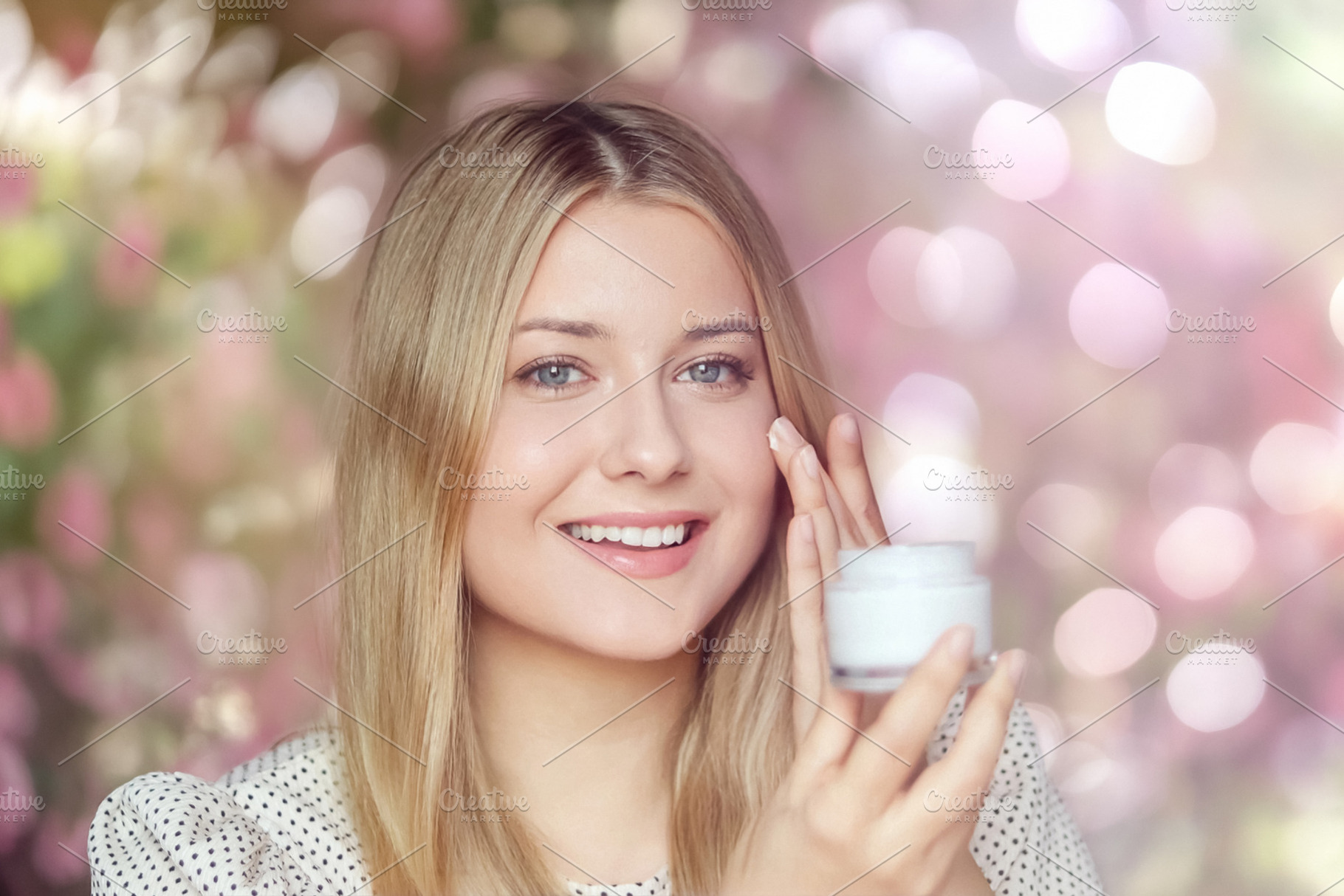Young woman applying face cream, smiling, practicing daily skinc, a Person Photo by Studio ANNA