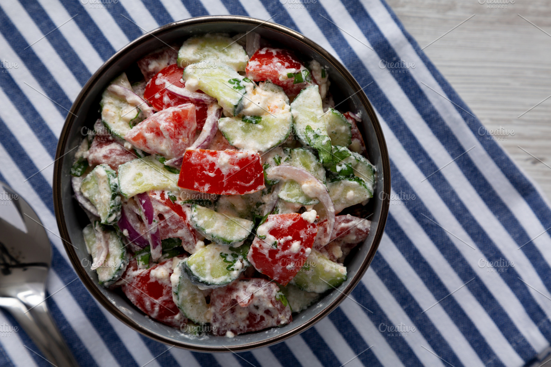 Homemade Tomato Cucumber Feta Salad in a Bowl, top view. Flat la, a Food & Drink Photo by LiudmylaChuhunova