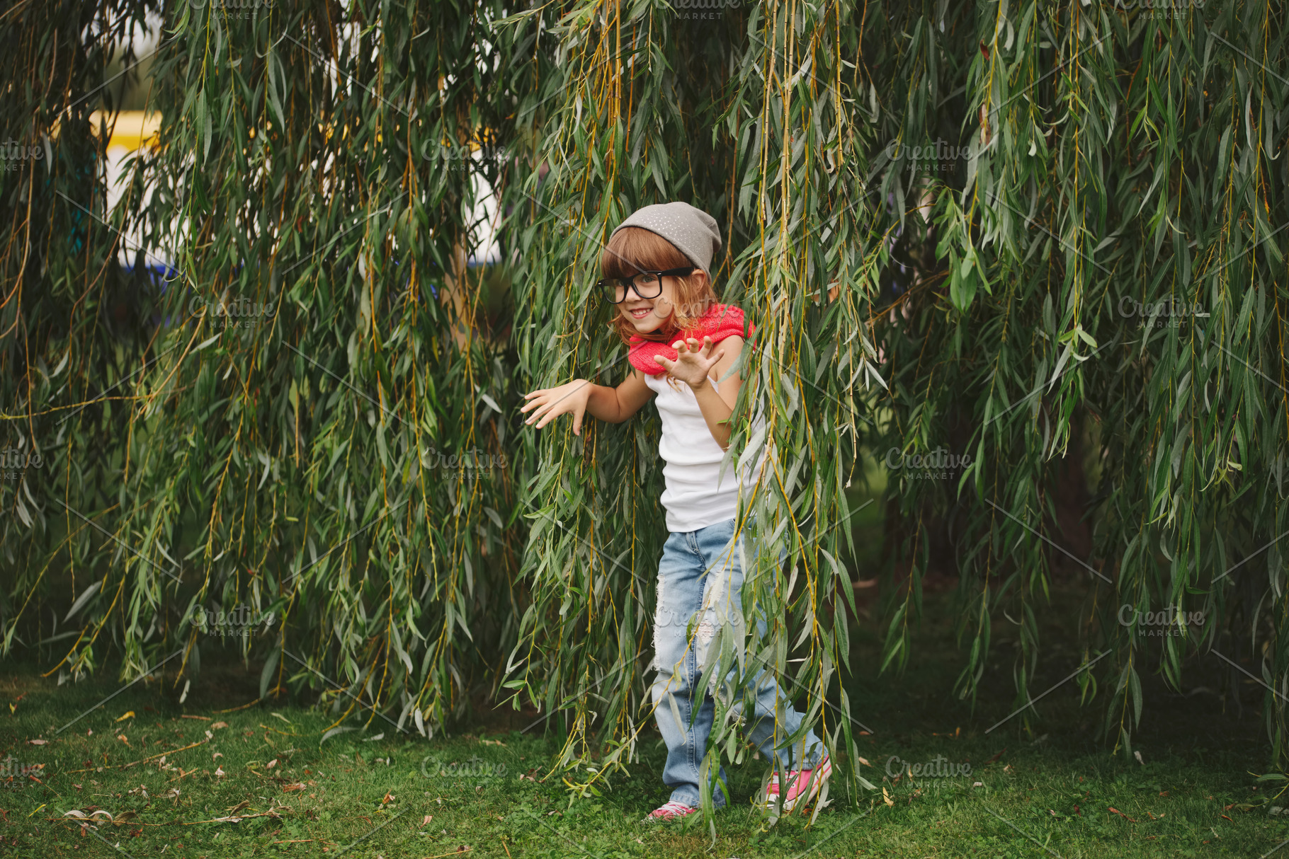 Little girl hiding in the willow foliage stock photo containing playing and, a Person Photo by AlohaHawaii