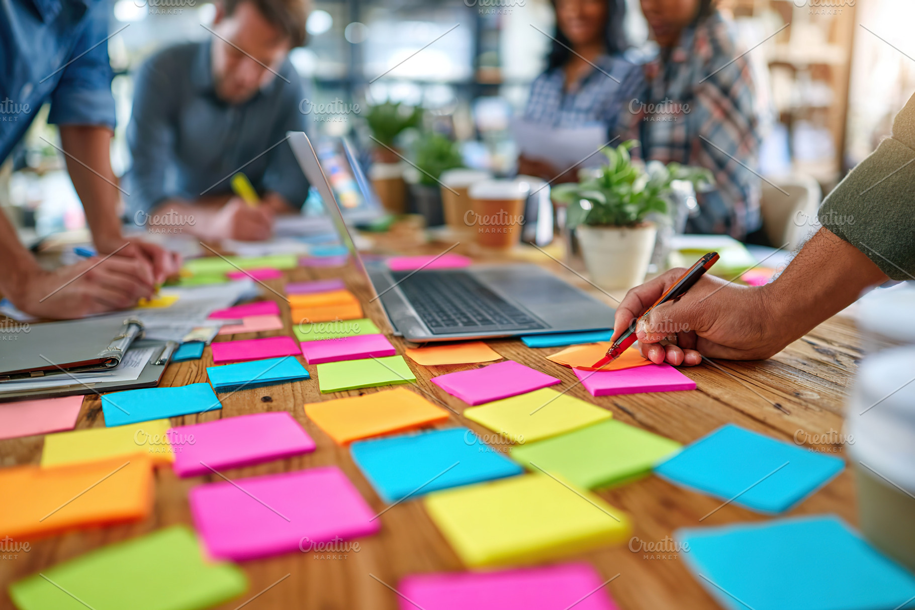 Team collaborates on brainstorming ideas using sticky notes in a modern workspa, a Photo by AlyaAnd