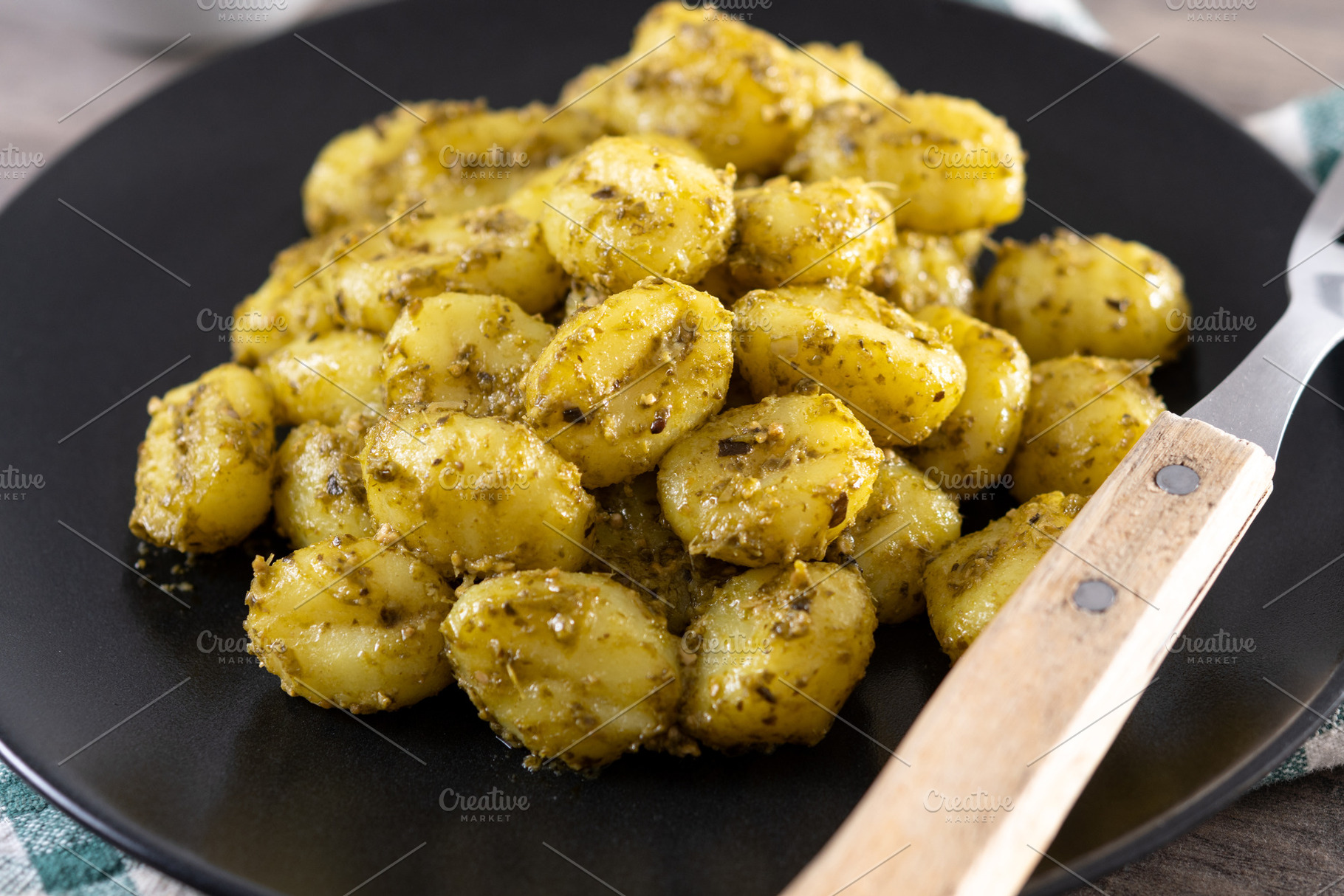Gnocchi with pesto sauce served on black plate, a Food & Drink Photo by etorres69