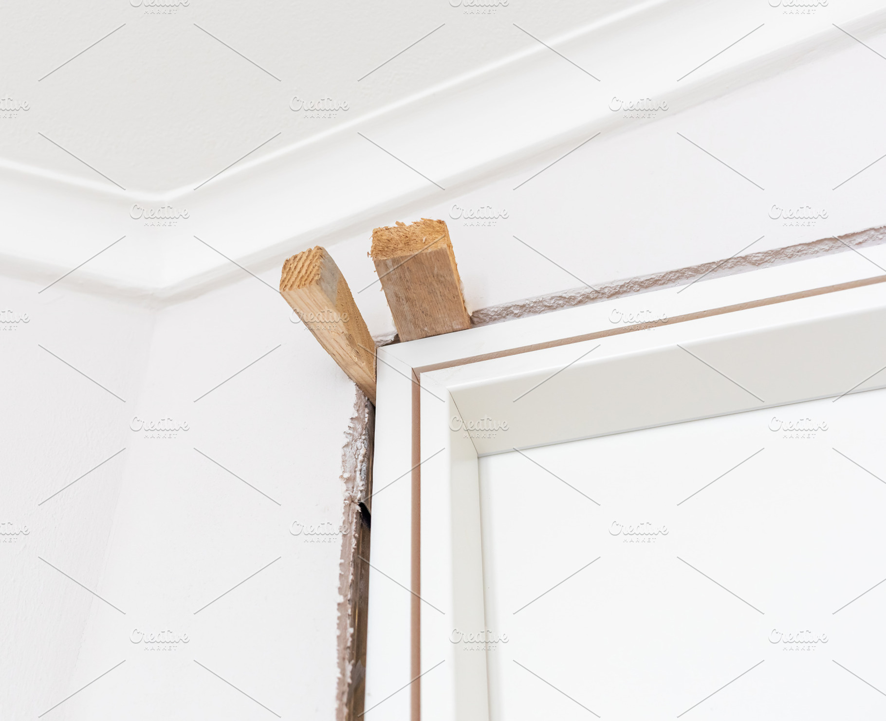 Construction worker installing new interior door frame, an Architecture Photo by Antonio Gravante Market