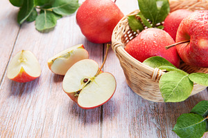 Fresh red apples in basket with green leaves, a Food & Drink Photo by Olena Rudo