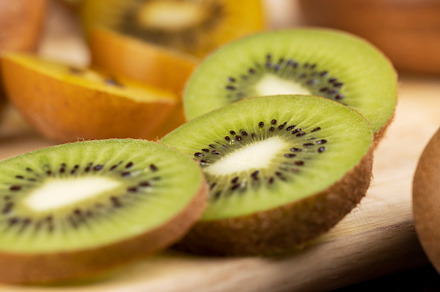 green and yellow kiwi fruit cut into pieces, close up, a Photo by MyPhotos