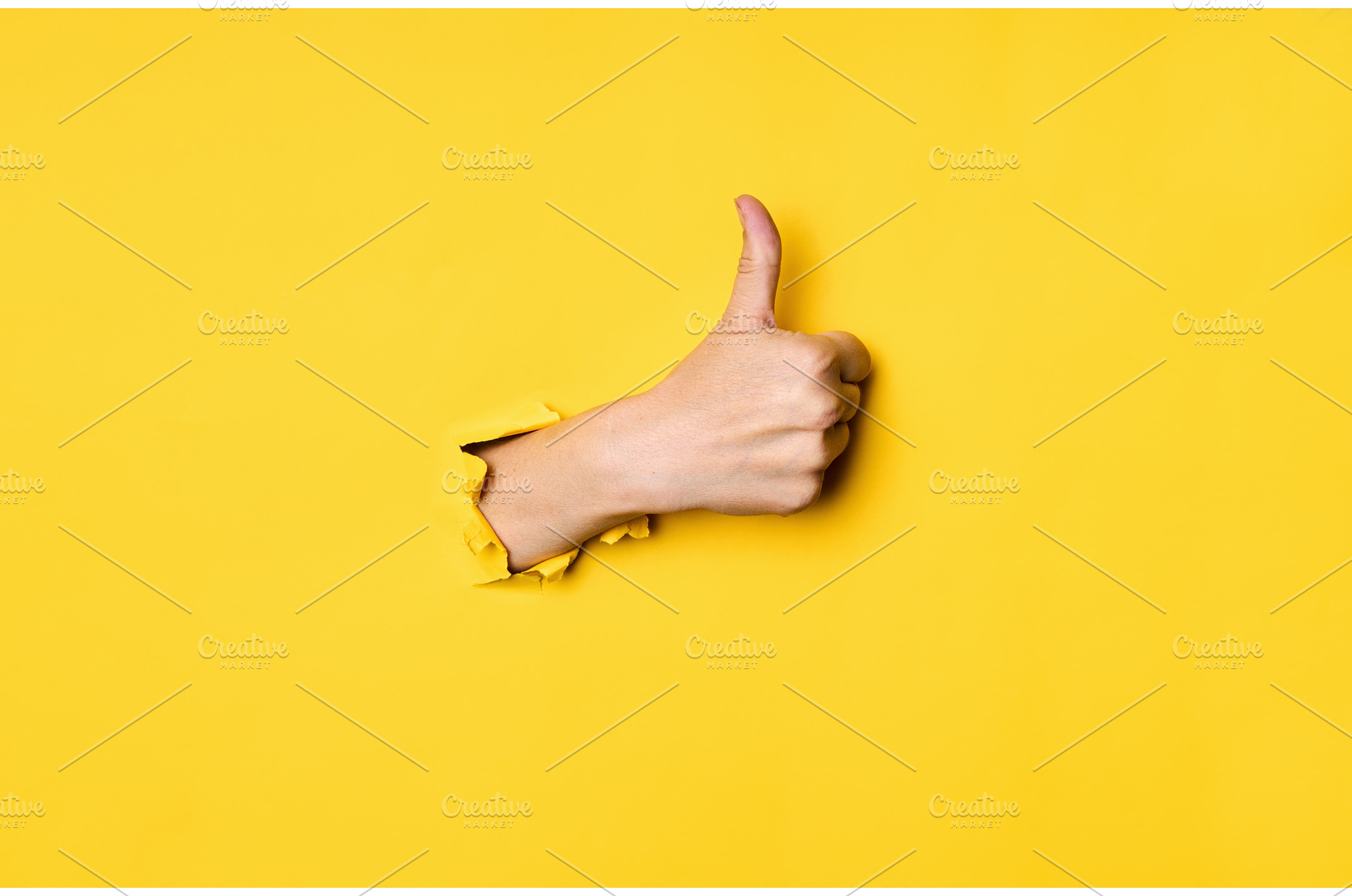 Thumb up hand gesture through hole, a Business Photo by Gladkov photography