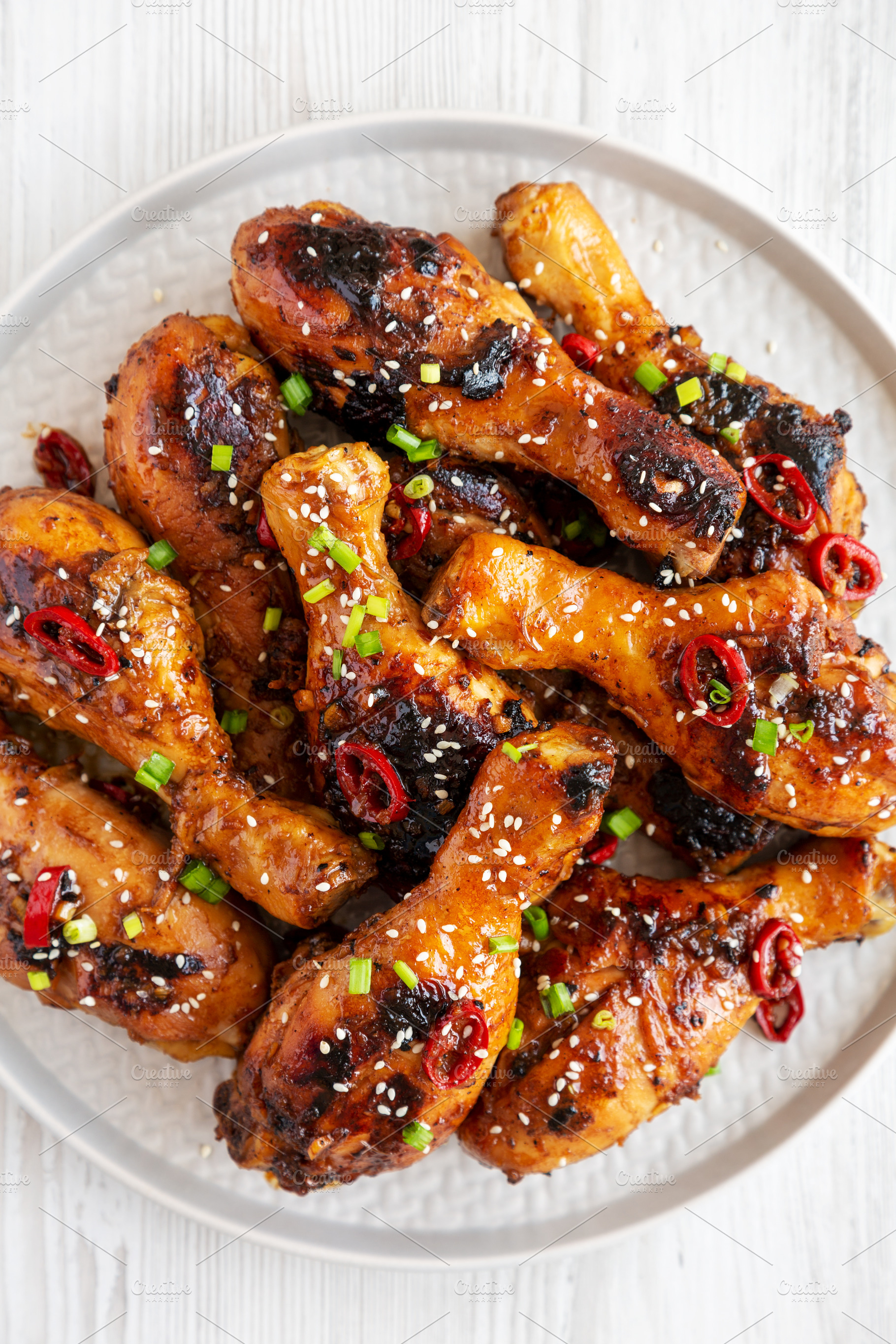 Homemade Easy Sticky Chicken Drumsticks on a Plate on a white wo, a Food & Drink Photo by LiudmylaChuhunova