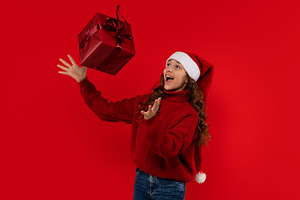 Excited girl in Santa hat, a Holiday Photo by Elena Vagengeim