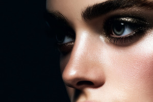 Woman's eye with dramatic glitter eyeshadow and highlighted skin, a Beauty & Fashion Photo by Studio ANNA