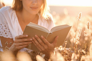 Young Woman Reading Book in Golden Meadow, a Photo by Davizro's Market