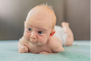 One-month-old baby lying on tummy, a Person Photo by Elizaveta Galitskaya