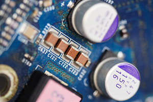 Vertical macro shot of blue circuit board with capacitors and microchips., a Technology Photo by Rohan Photography