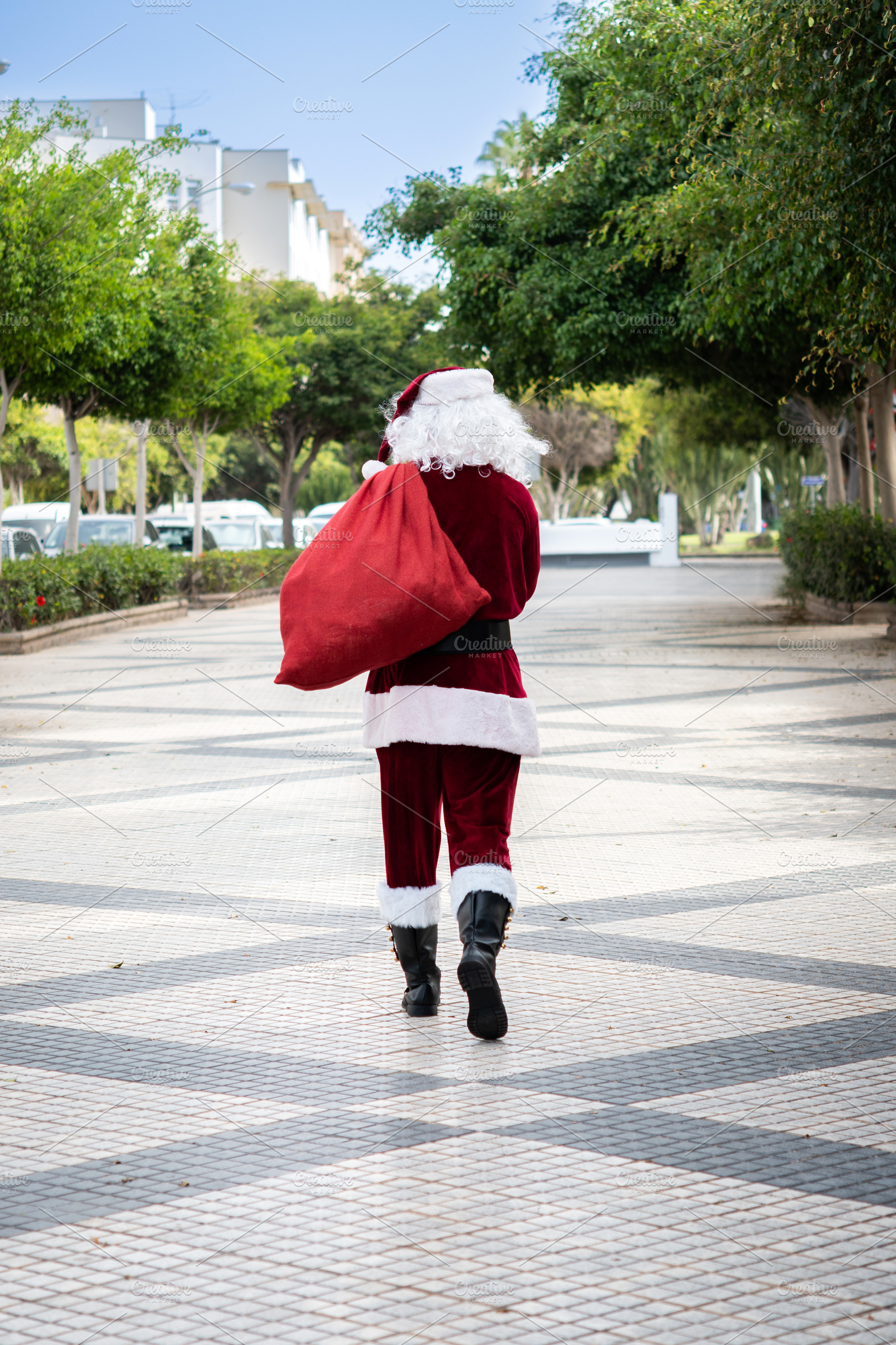 Santa Claus walking through the city with a red gift sack, a Holiday Photo by etorres69