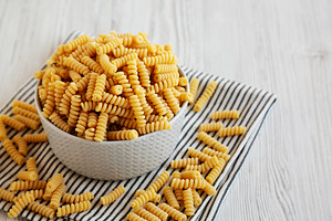 Uncooked Organic Dry Fusilli Pasta in a Bowl, side view. Copy sp, a Food & Drink Photo by LiudmylaChuhunova