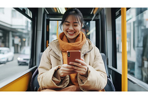 A young Asian woman is smiling while, a Technology Photo by Sergey Kotenev