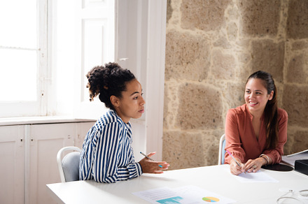 Two women sitting at a table talking