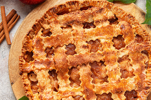Freshly baked apple pie decorated with cinnamon sticks and apple, a Food & Drink Photo by Olena Rudo