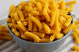 Dry Fusilli Pasta in a Bowl, side view. Close-up., a Food & Drink Photo by LiudmylaChuhunova
