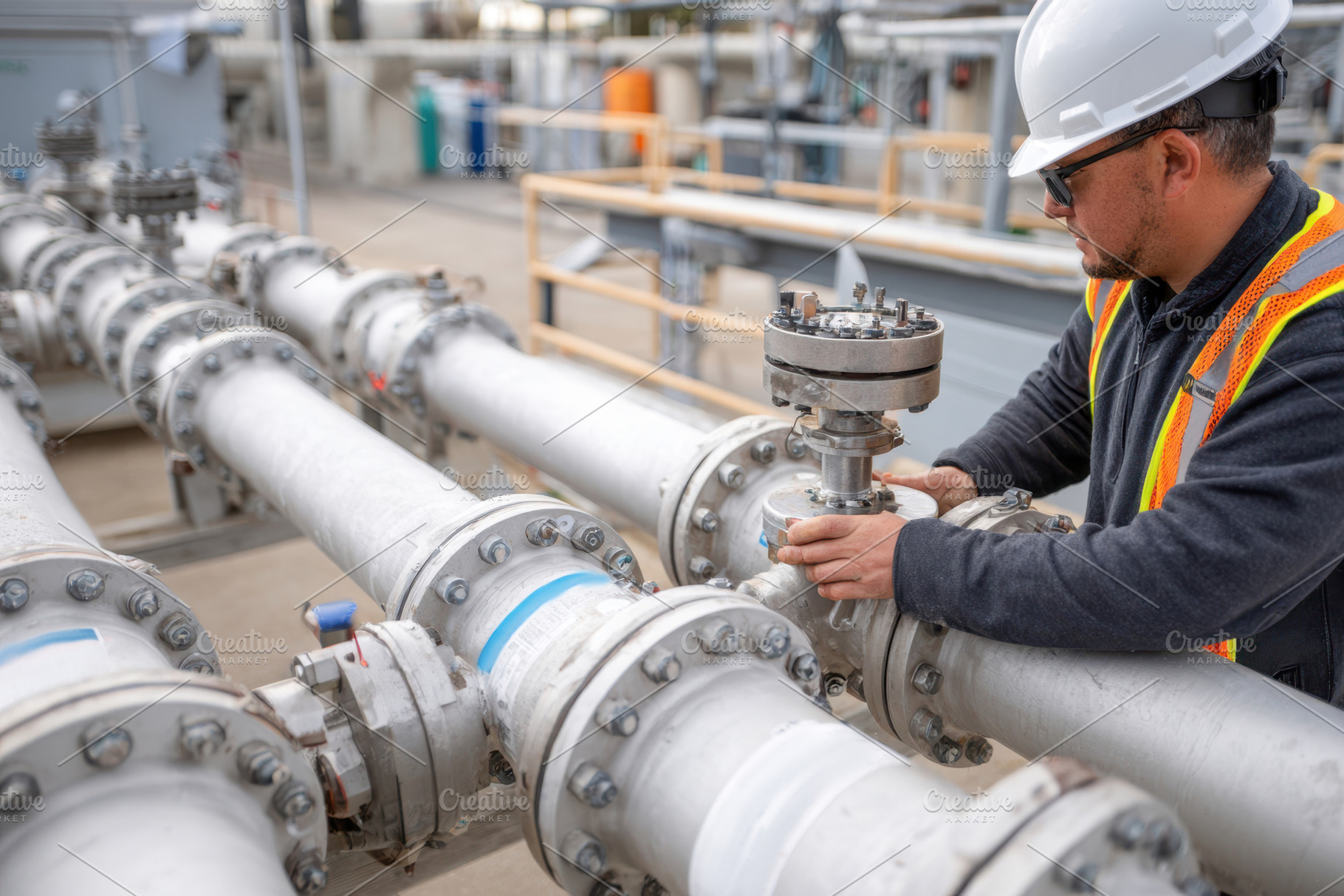 Industrial workers tightening pipes at construction site, an Industrial Photo by AlyaAnd