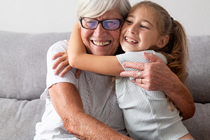 Happy grandmother hugging her granddaughter at home, a Person Photo by etorres69