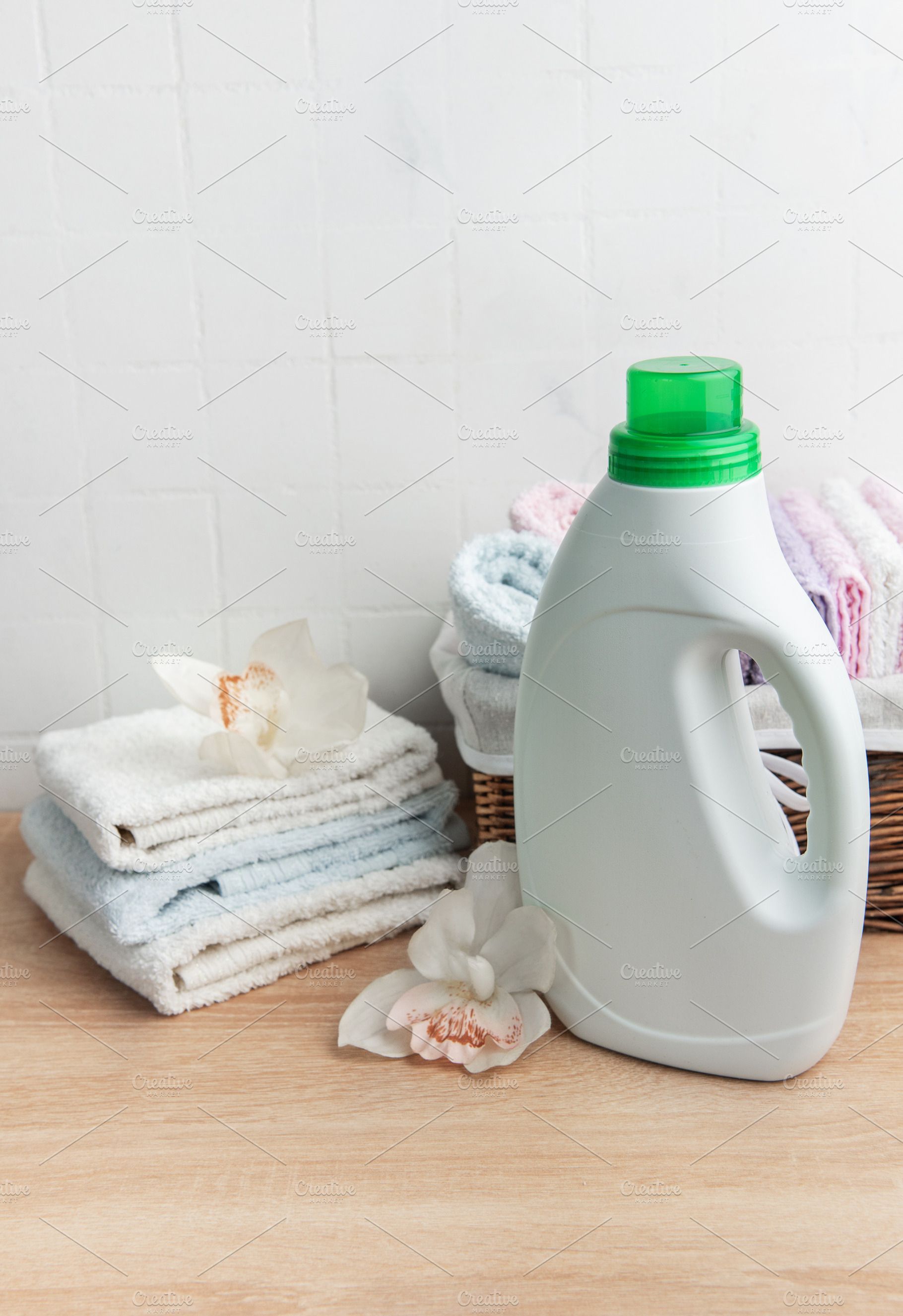 Laundry detergent bottle with fresh clean towels and orchids, an Industrial Photo by Olena Rudo