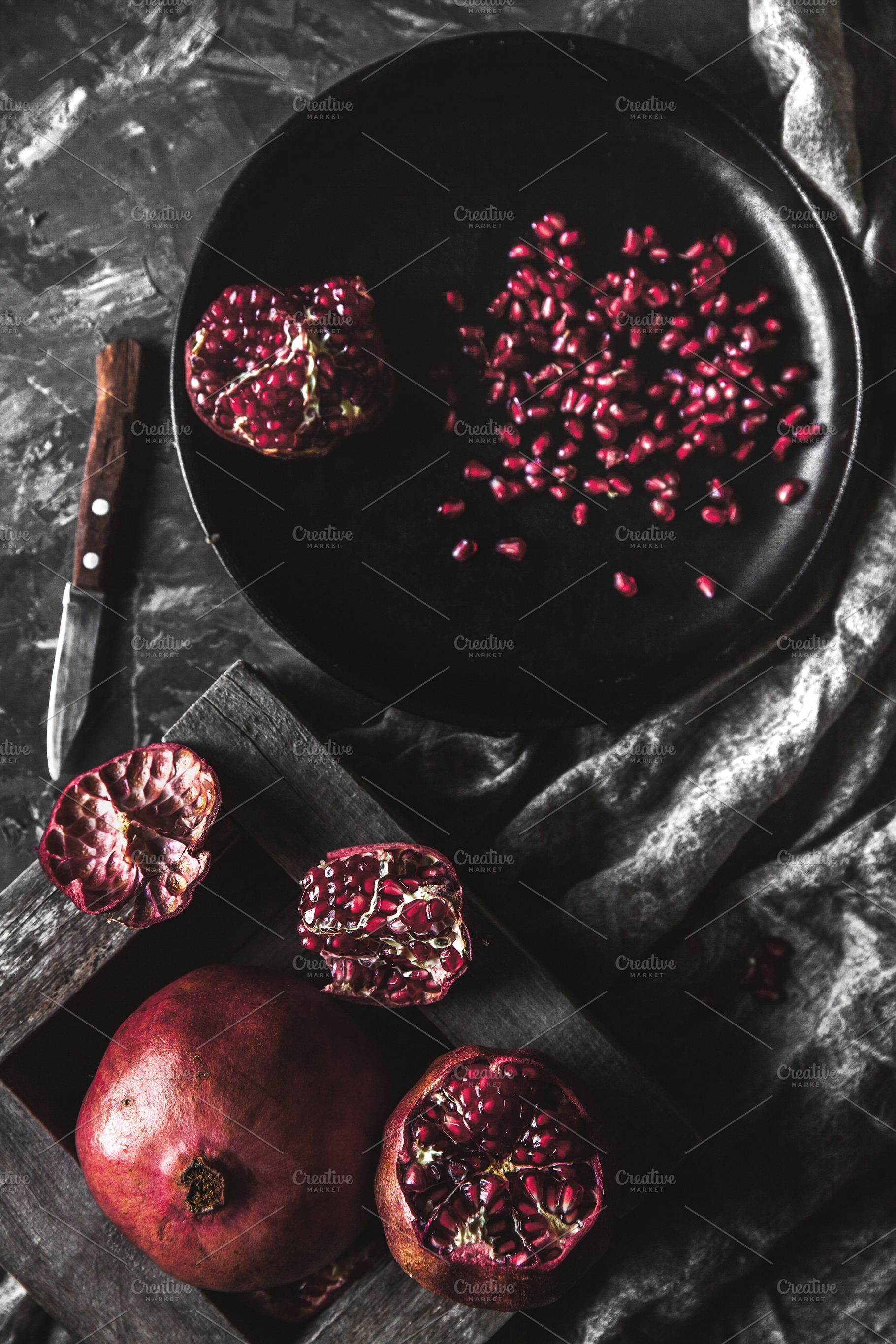 Pomegranate in a black box on a dark, a Background Photo by OS