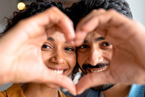 Happy diverse couple forming heart shape, a Person Photo by Davizro's Market