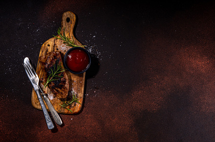 Grilled meat steak on dark table, a Food & Drink Photo by Rimma