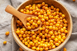 Sea buckthorn berries in wooden bowl, a Food & Drink Photo by Olena Rudo