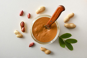Peanut butter in a jar and peanuts in the center, a Food & Drink Photo by Davizro's Market