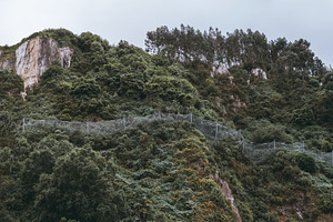 Rockfall net on green hillside, a Nature Photo by SkyNext