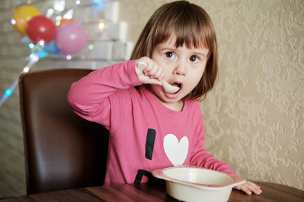 Cute Little Girl 2 Years alone eats porridge with a spoon., a Person Photo by Rohan Photography