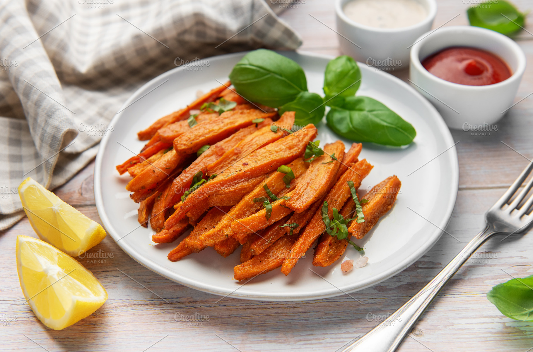 Roasted sweet potato fries on plate with basil and dipping sauce, a Food & Drink Photo by Olena Rudo