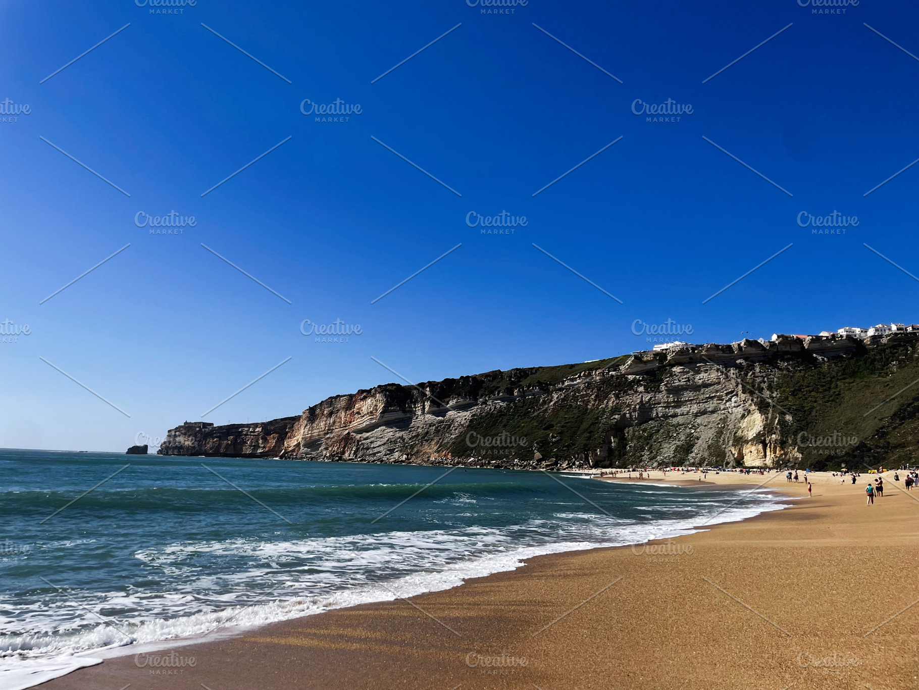 Golden sandy beach with waves and cliffs in picturesque Nazare, Portugal settin, a Photo by AS photostudio