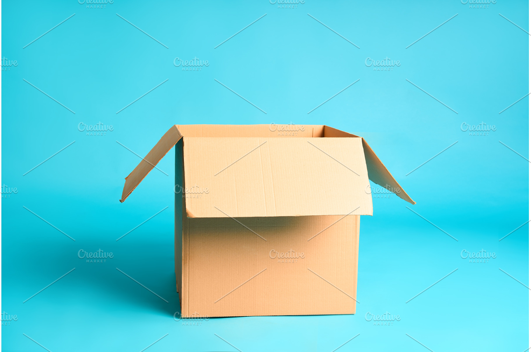 Open cardboard box on vibrant blue, a Background Photo by Gladkov photography