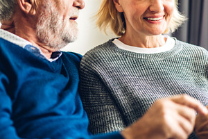 Senior couple relaxing and talking together sitting on sofa in l