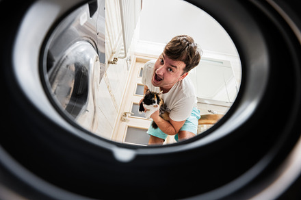 Man with cat view from washing machine inside. Male does laundry, a Person Photo by AS photostudio