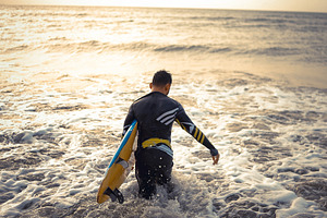 Surfer Entering Ocean at Sunset, a Sports & Recreation Photo by bastera