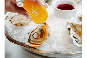 Woman having oysters at table, a Food & Drink Photo by Fascinadora