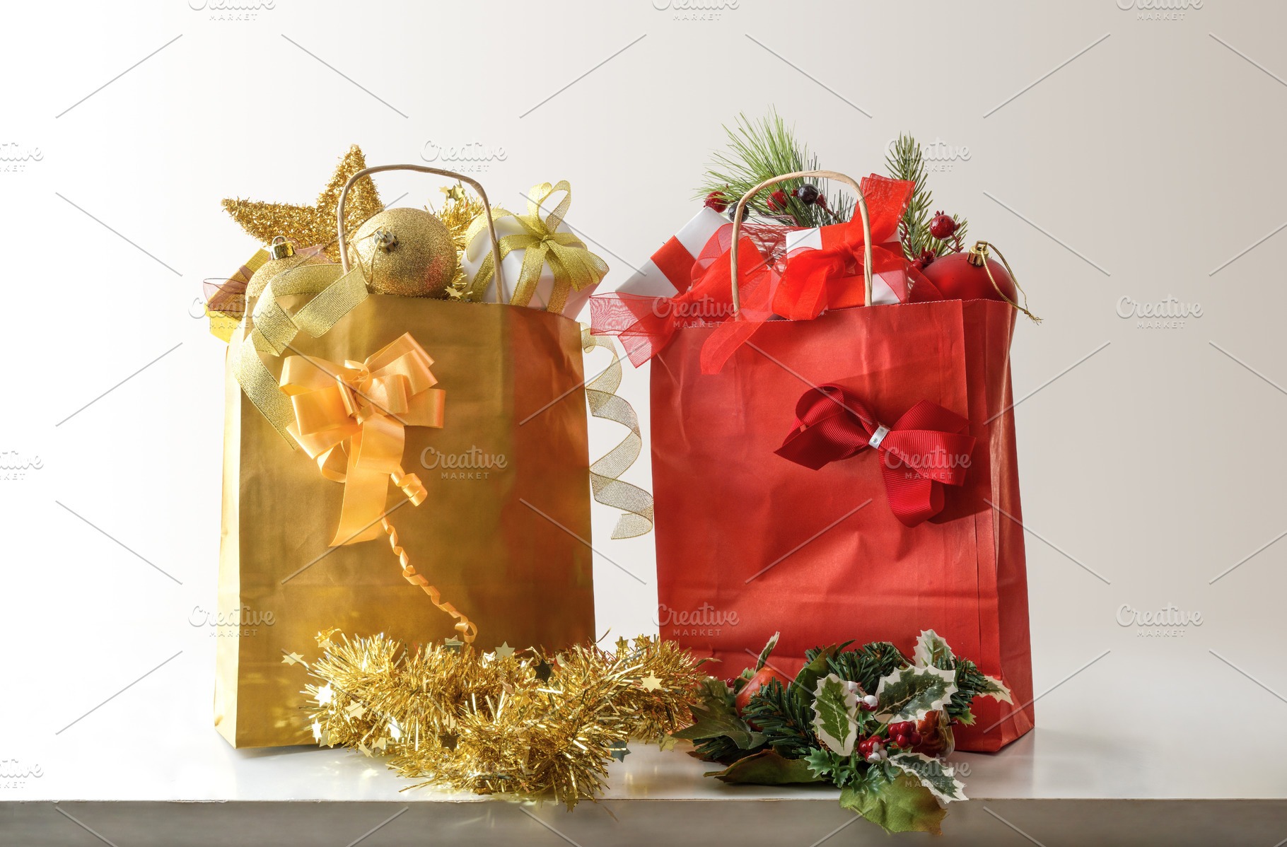 Red and gold gift bags with Christmas decorations on table, a Holiday Photo by Davizro's Market