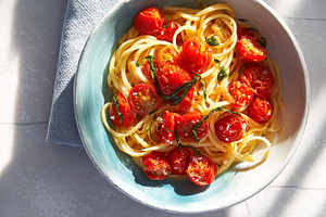 Spaghetti with juicy roasted cherry tomatoes and fresh basil lea, a Photo by Studio ANNA