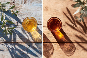 Glass of golden drink casting shadows on rustic wooden surfaces in afternoon li, a Photo by AlyaAnd