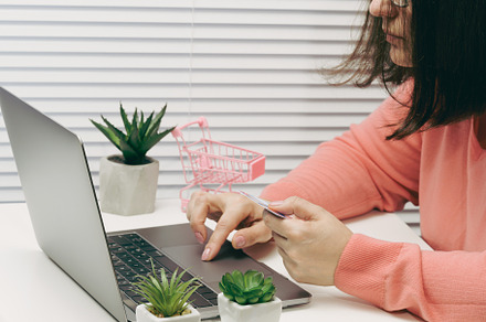 woman in a pink sweater makes purchases online with a laptop, a, a Person Photo by ndanko