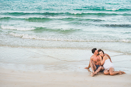 Handsome man and pretty woman sitting on the beach, a Person Photo by Svetlana Barchan