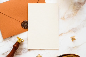 Feminine wedding stationery top view. Blank wedding invitation, bronze envelope