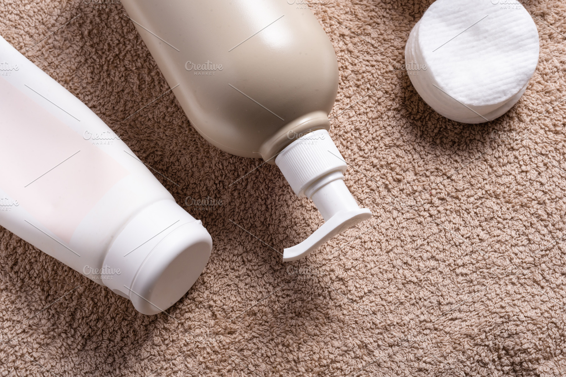 Plastic bottle with dispenser for massage oil on brown towel, a Health & Medical Photo by MDBildes