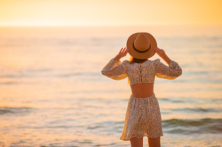 Young happy woman on the beach enjoy her summer vacation at sunset, a Person Photo by travnikovstudio
