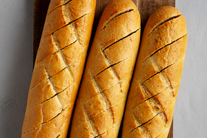 Homemade French Baguette with Garlic Filling on a wooden board,, a Food & Drink Photo by LiudmylaChuhunova